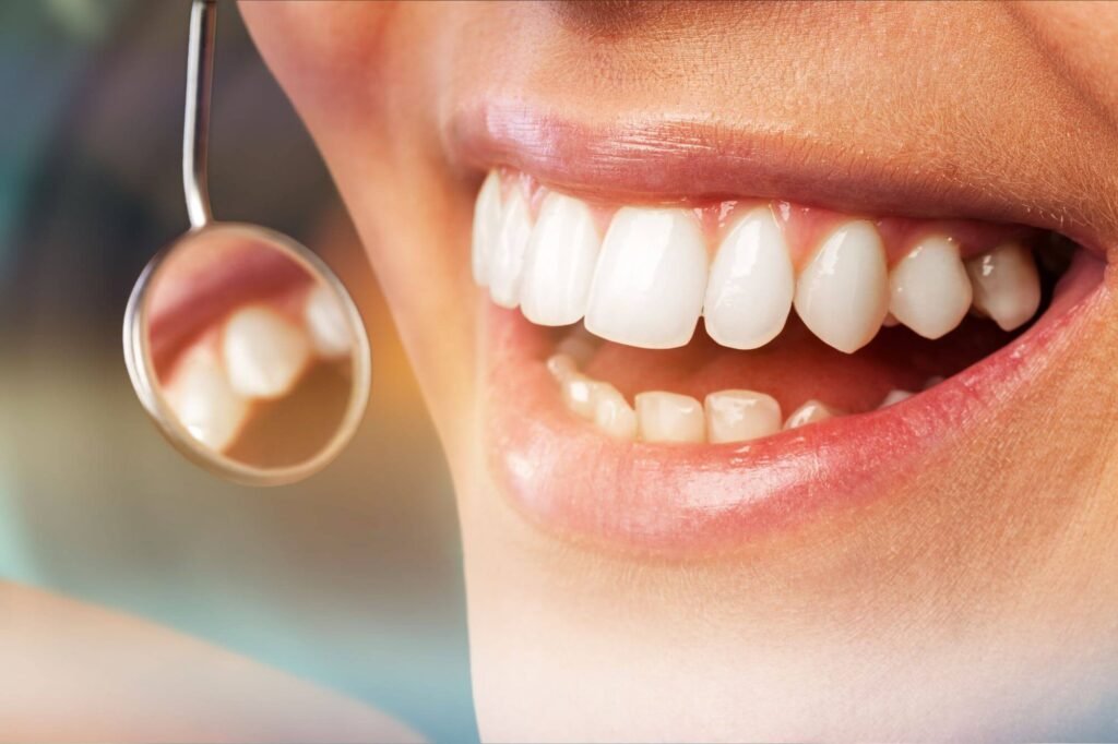 Checking her white teeth by a dental mirror